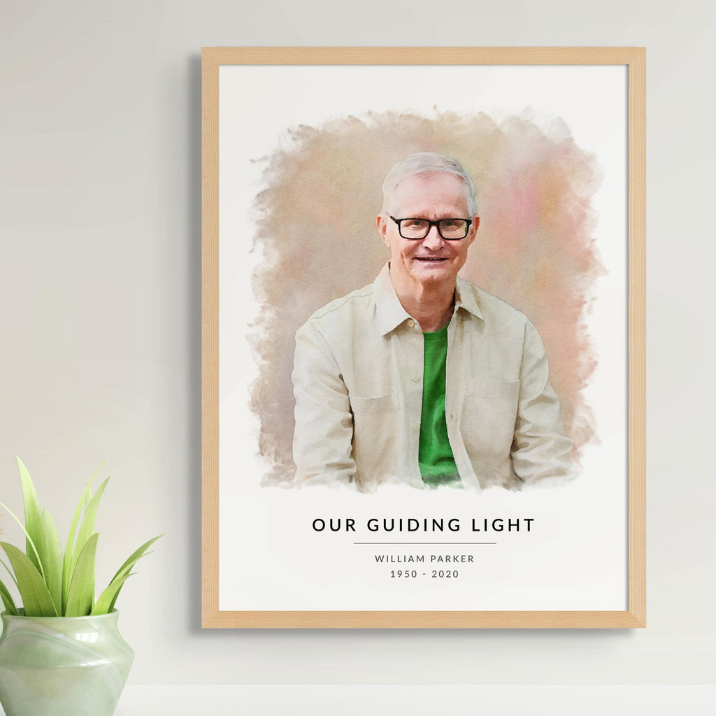 Watercolor-style memorial portrait of a man in glasses and a green shirt, in a light oak frame, 'Our Guiding Light'