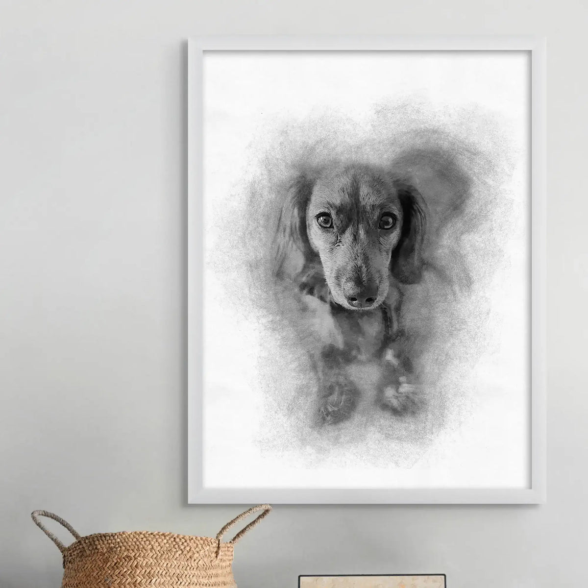 Sketch-style portrait of a small long-eared dog with no name text, in a white frame above a woven basket
