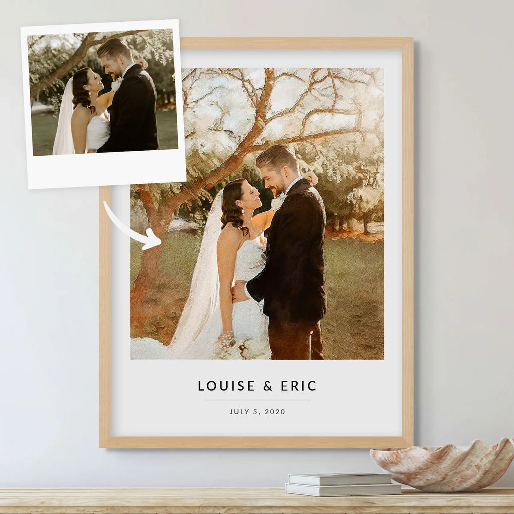 Oil-style portrait of a bride and groom in a light oak frame, with a small snapshot of the same moment at top left