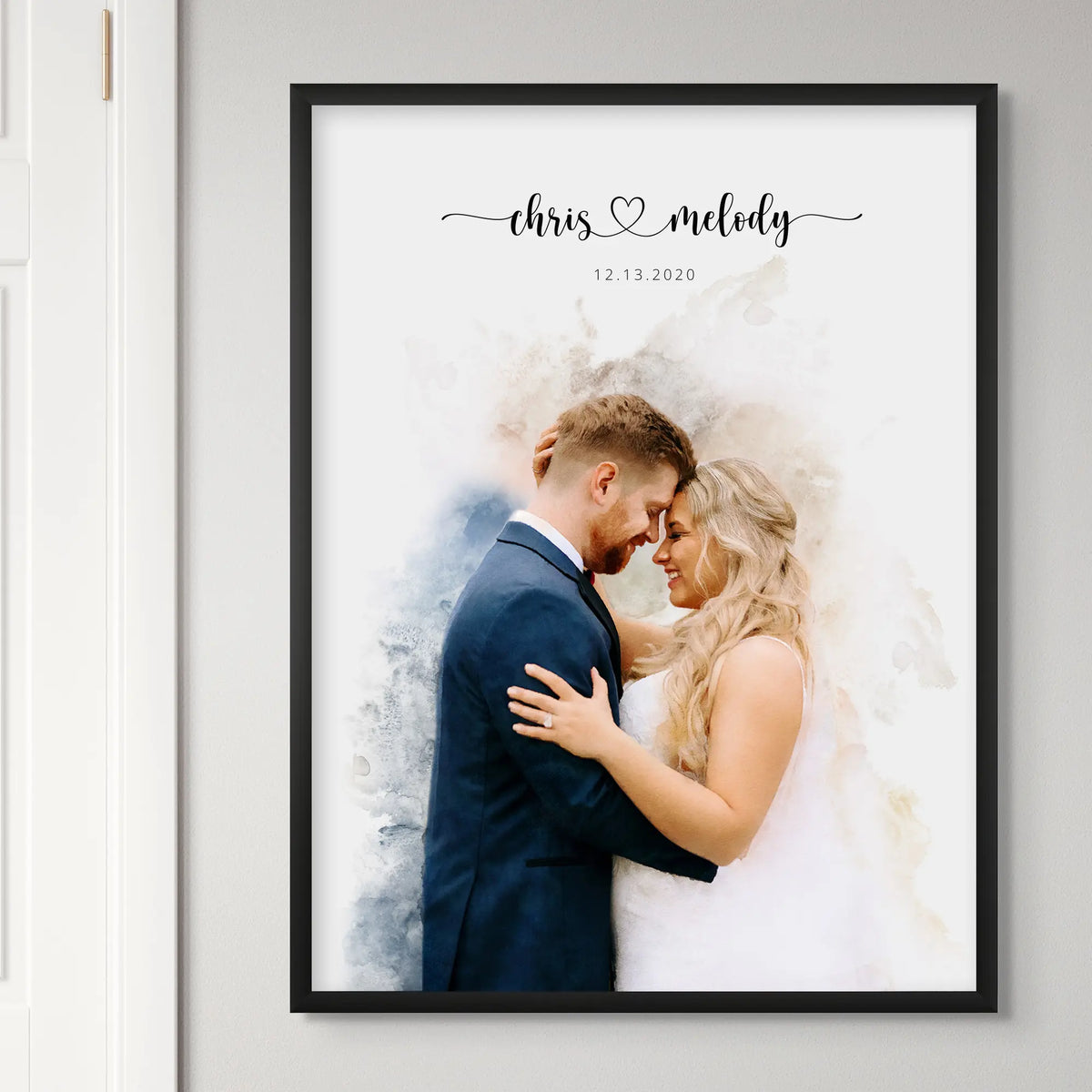 Watercolor-style wedding portrait of a bride and groom forehead to forehead, names and date above, framed in matte black