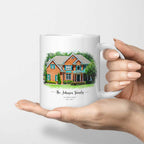 White mug printed with a watercolor-style portrait of a red brick house and the title 'The Johnson Family', held in one hand